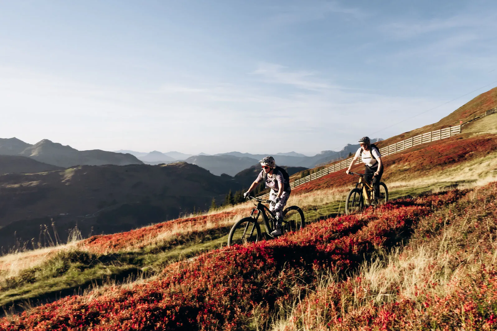 Twee mountainbikers op een bergflank met herfstkleuren