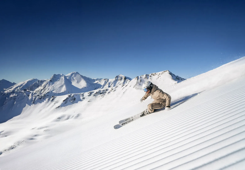 Skiër in poedersneeuw op een brede berghelling