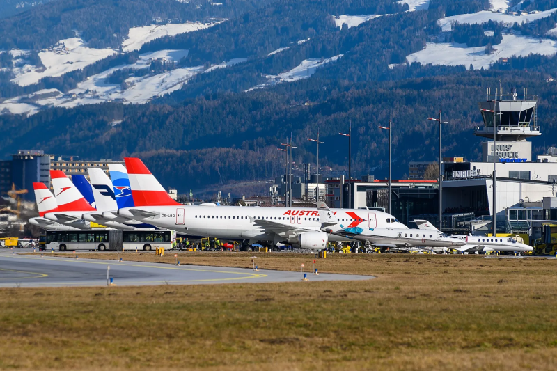 Vliegtuigen van Austrian Airlines op Innsbruck Airport met besneeuwde bergen