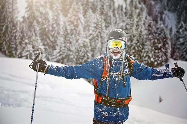 Wintersporter met de armen omhoog in de sneeuw bij Fieberbrunn