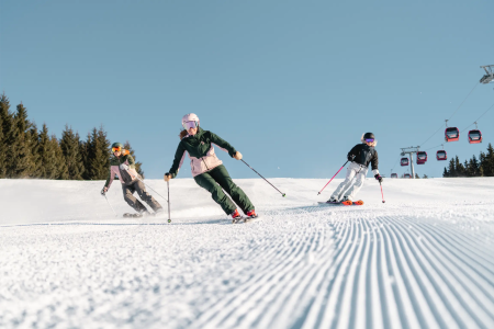 Skiërs op een geprepareerde piste in het skigebied Fieberbrunn